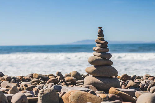 Rocks stacked on top of each other by a beach.